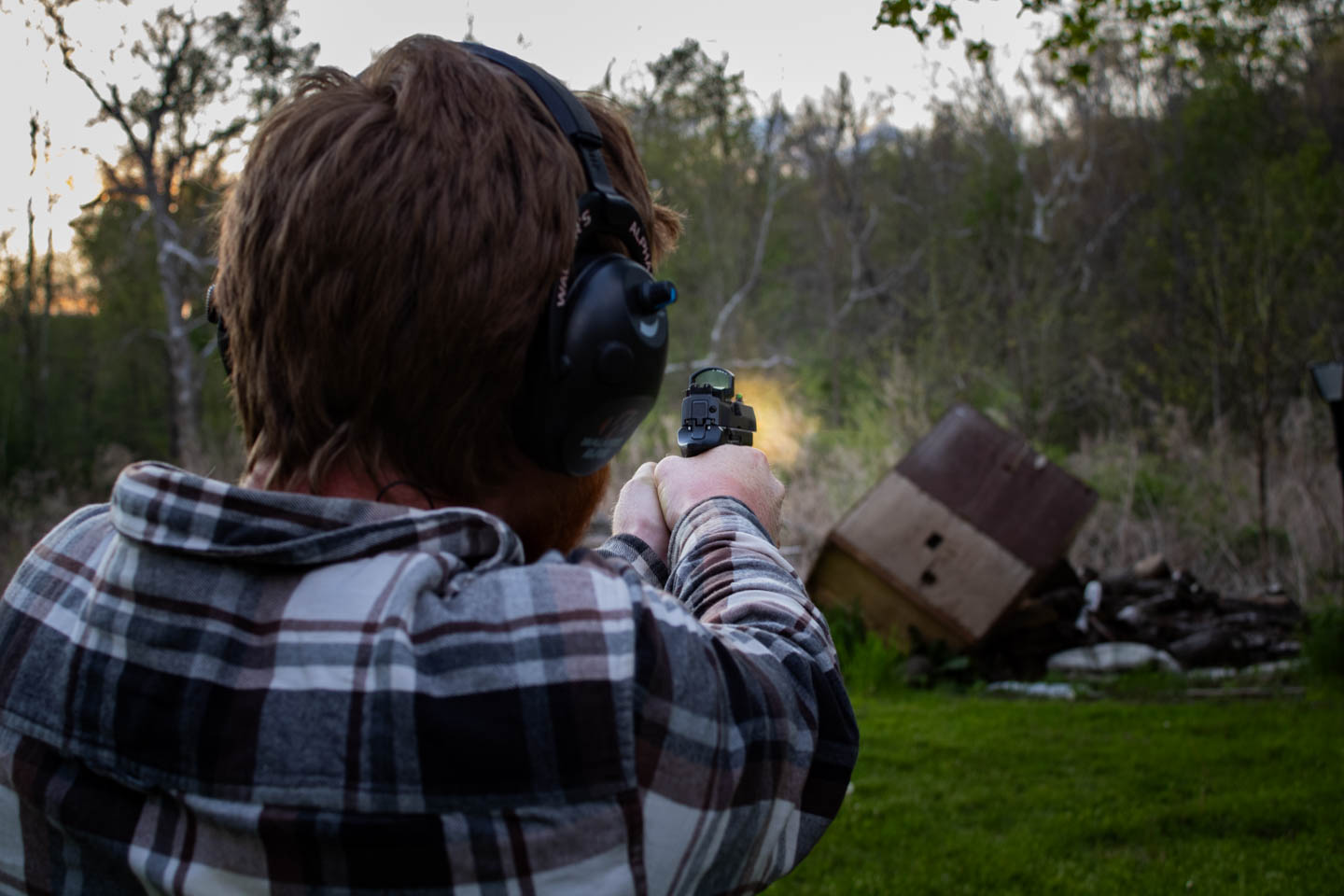 Man shooting a pistol, showing muzzle blast from 9mm