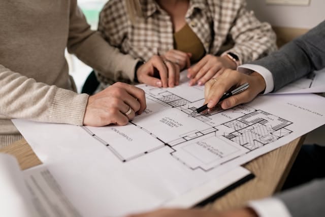three people looking at house plans